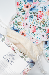 Close-up of CAE nursing pads' floral print fabric beside the box